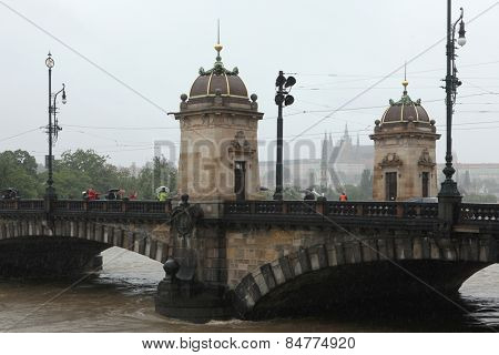 PRAGUE, CZECH REPUBLIC - JUNE 3, 2013: People observe the rising water from the Legion Bridge partially flooded by the swollen Vltava River in Prague, Czech Republic. 