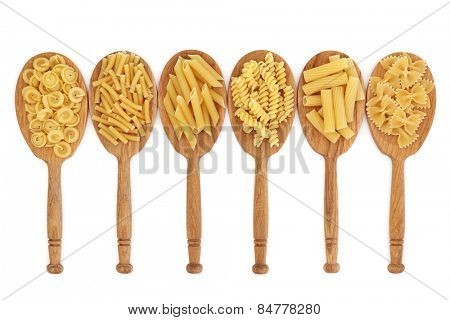 Pasta food selection in oak wood spoons over white background.