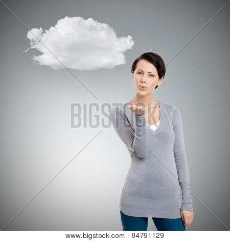 Beautiful woman throws a kiss, grey background with cloud