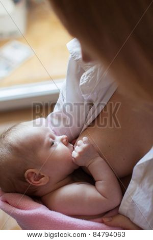 Brestfeeding. Mother with newborn at home.