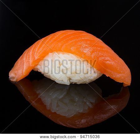 Salmon sushi nigiri clodeup over black background with reflection