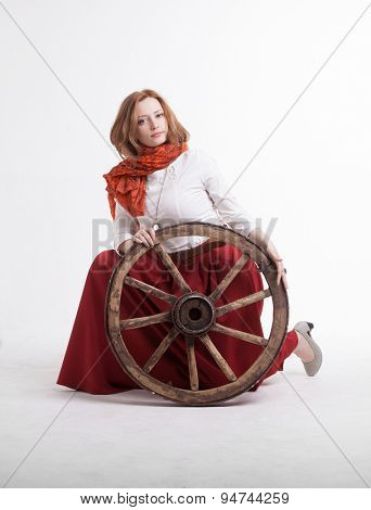 young woman with an old wagon wheel on white background