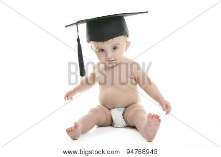 Portrait of a sitting baby with a graduation cap