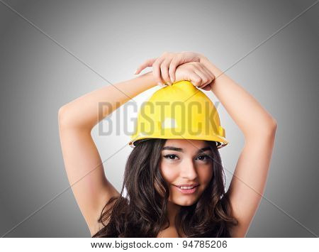 Young woman with hellow hard hat against gradient 