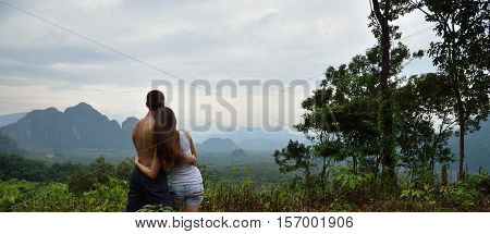 Couple of tourists admiring the view from the mountains, tropical jungles, Thailand, vocation.