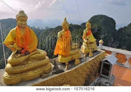 Tiger Cave Temple in Thailand, Krabi. Golden Buddha statues, located high above the mountain, after steep climb of 1237 stairs.