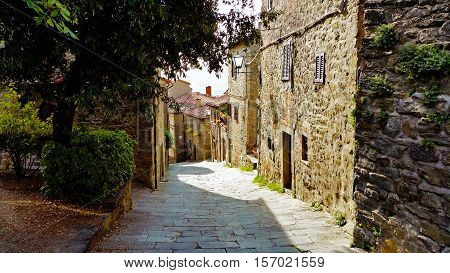 Old italian village in Tuscany. Pedestrian road between old buildings down the hill.