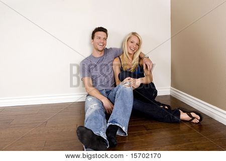 Привлекательные молодая пара, сидя в их новом доме