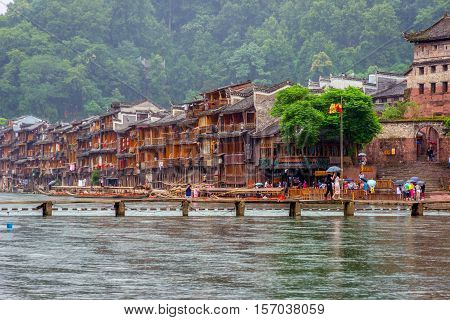People Crossing Famous Bridge In Fenghuang, Xiangxi, China
