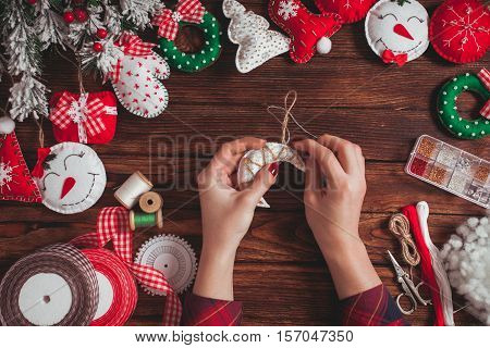 felt Christmas decorations on the wooden table - woman is preparing for handmade