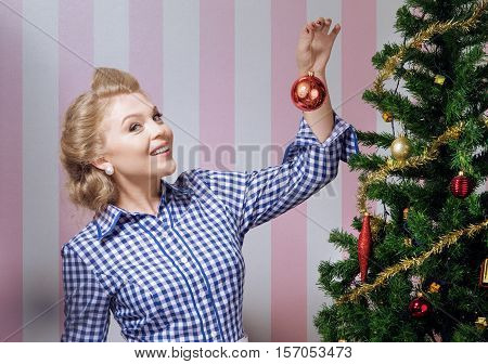portrait of nice young woman hanging around christmas tree on x-mas  eve