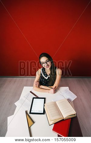 Young attractive brunette happy girl in glasses studying with book