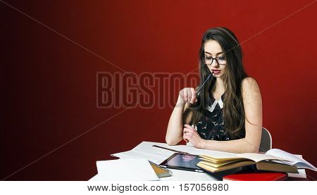 Attractive brunette student girl in glasses, table workplace with books and tablet pc