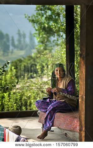 Naggar India - July 21 2011: Women knitting clothes for small scale industry in villages. Selling handmade clothes is a form of hers income.