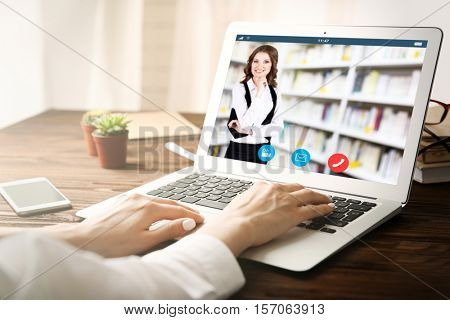 Woman video conferencing with tutor on laptop at home. Distance education concept.