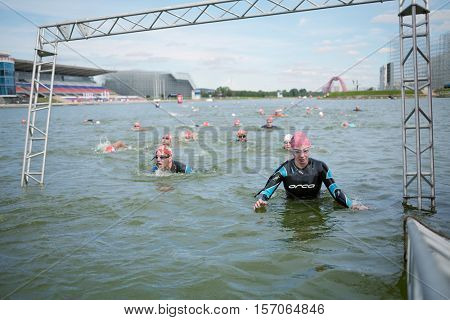 MOSCOW, RUSSIA - AUG 14, 2016: Participants of swimming stage of traditional 3Grom series triathlon contest in Krylatskoye Rowing Channel.