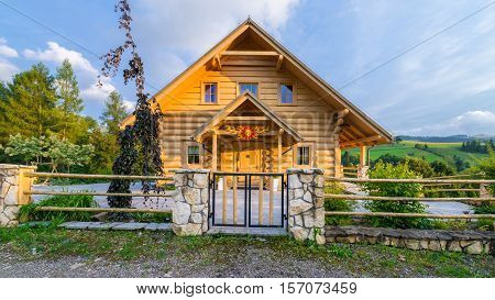 Traditional Wooden Mountain House Built From Wood Logs On Summer Sunny Day