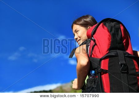 Escursionista alla ricerca mentre trekking / escursioni a piedi nella natura. Copia spazio sul cielo blu.