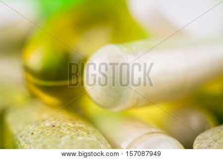 Mixed natural food supplement pills omega 3 multivitamin and glucosamine capsules macro image