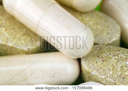 Mixed natural food supplement pills multivitamin and glucosamine capsules macro image