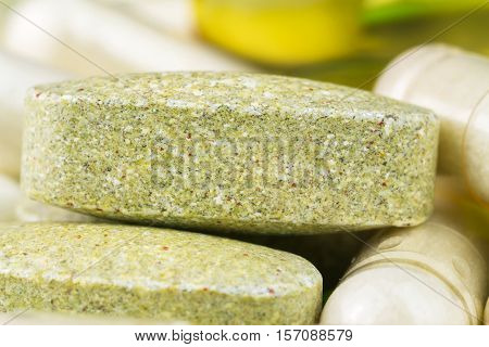 Mixed natural food supplement pills multivitamin tablet and glucosamine capsules macro image