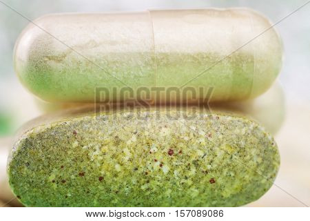 Mixed natural food supplement pills multivitamin tablet and glucosamine capsules macro image