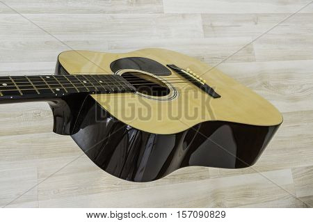 Acoustic guitar on a light wooden background