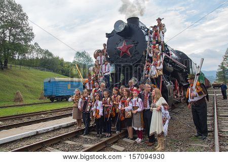 Yasynya Ukraine - September 29 2016: Musicians in national dress posing against the backdrop of the old steam locomotive as part of Phase 2 of the International Conference 
