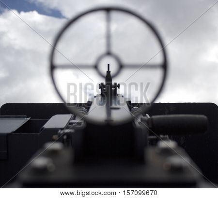 Sighting a vintage WWII gun pointed towards the sky, war concept point of view