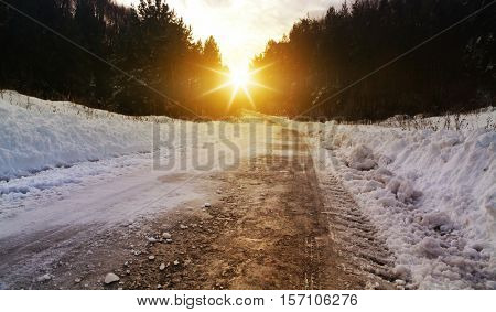 Snow covered winter road with shining streetlights  in rural areas