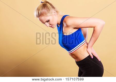 женщина держится за поясницу после тренировки