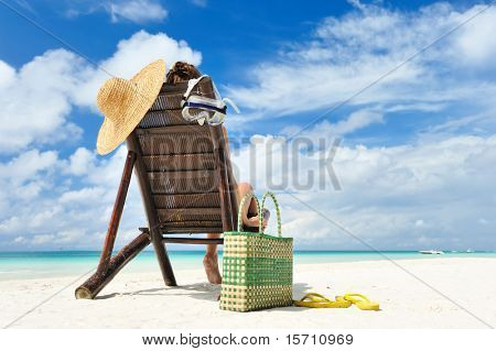 Ragazza su una spiaggia tropicale con cappello
