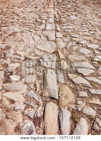 Cutting Of An Old Road With Cracked Asphalt And A Gully In The Center Of Cobblestones