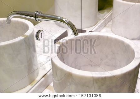 Indoor modern water sink with mirror reflection in the restroom