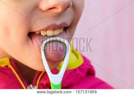 Closeup child brushing his tongue.  Tongue scraper.