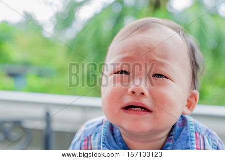 cute baby crying in the park asian