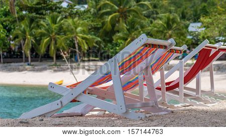 Appealing Beach Chairs on Sand. Palm Trees and Ocean in Background. Haad Salat. Koh Pangang, Thailand.
