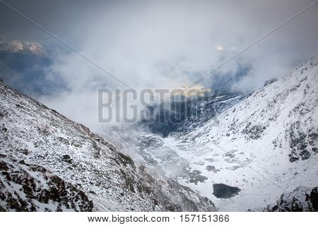 view on foggy valley in winter from Rodna Mountains in Transylvania - Romania