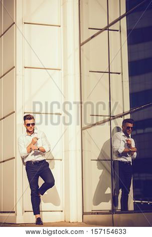 attractive young male model posing outdoors in white shirt and glasses