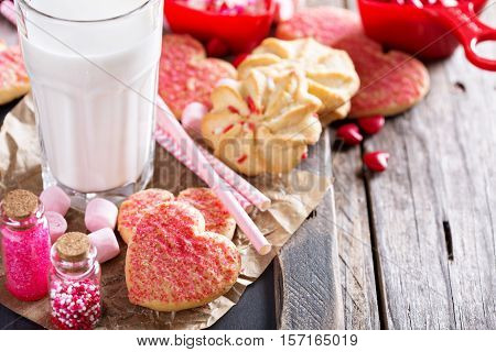 Valentine's day cookies decorated with sprinkles and a glass of milk