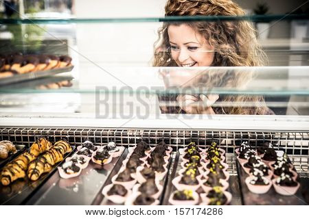 Woman watching pastries from a window. Concep about food