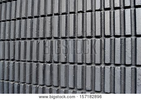 Black walls a vertical rectangular blocks arranged in a row.