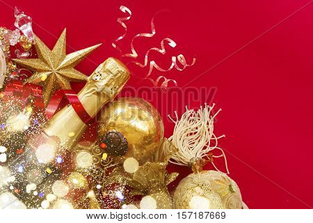 christmas decorations with bottle of champagne on red background flat lay scene with bokeh bright lights