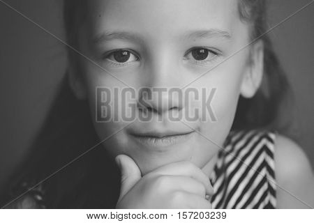 Face portrait of little cute happy girl smiling and posing closeup black and white