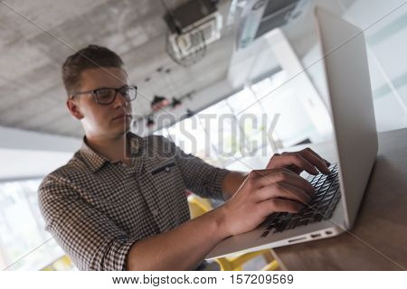 young businessman with glasses at  startup business office space working on modern  laptop  computer