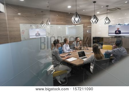 start up business people group attending videoconference call with senior investitior at modern office