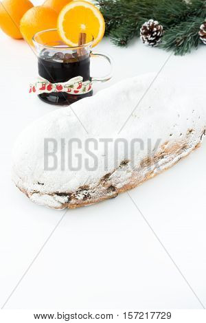 Whole Dresdner Christstollen mulled wine oranges and Christmas decoration on white background.