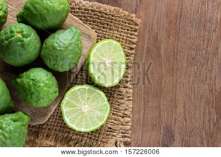 Close up fresh bergamot and bergamot slice on dark wood table background. bergamot on old wooden brown with copy space. (Bergamot or Kaffir lime)