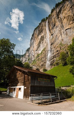 Building in front of the Staubbach Falls (Staubbachfall) more than 300 meters high in Alps near Lauterbrunnen Switzerland