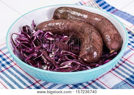 Homemade blood sausage with cabbage on a white background. Studio Photo